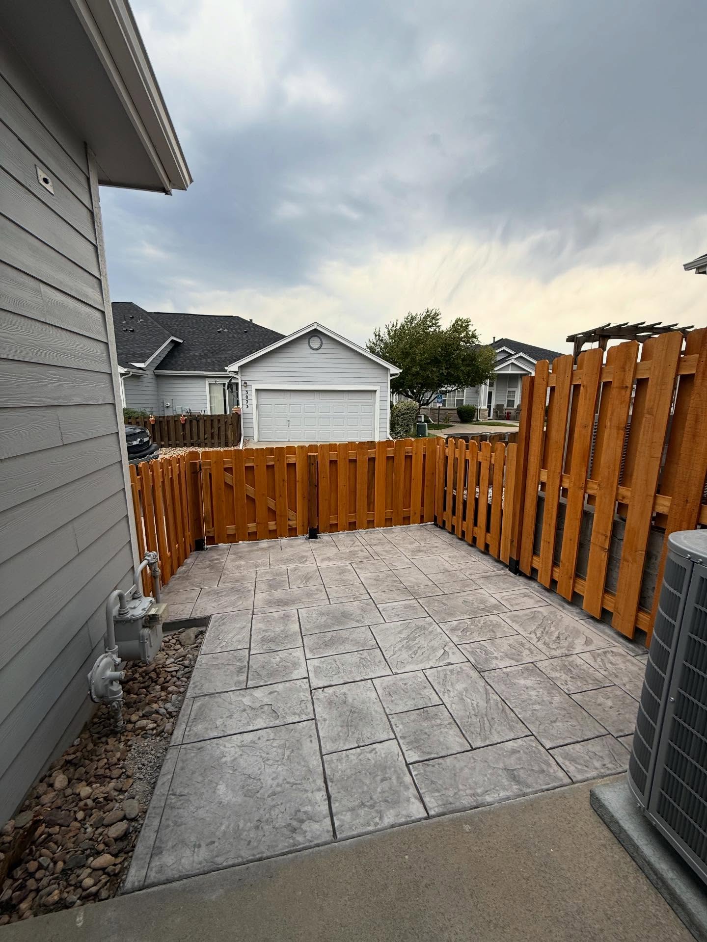 Finished stamped concrete patio and fence upgrade by Mountain Ridge Renovations
