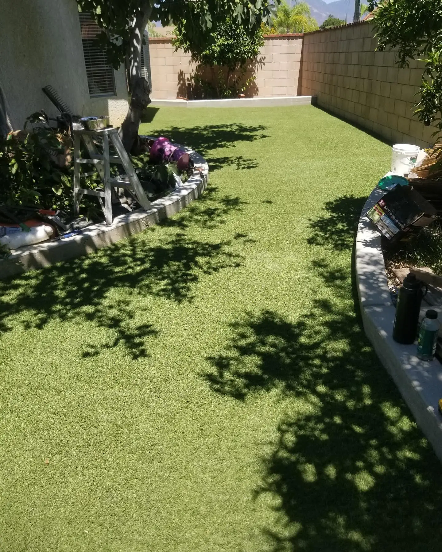 Turf installation with a curved cement curb offers a clean, modern by Mountain Ridge Renovations